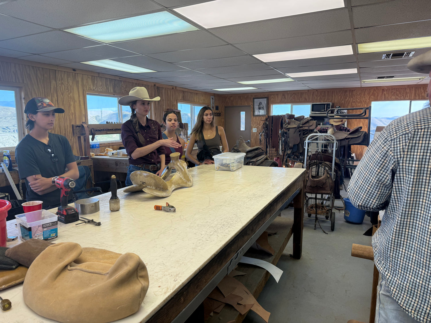 Group in the saddle shop discussing leather