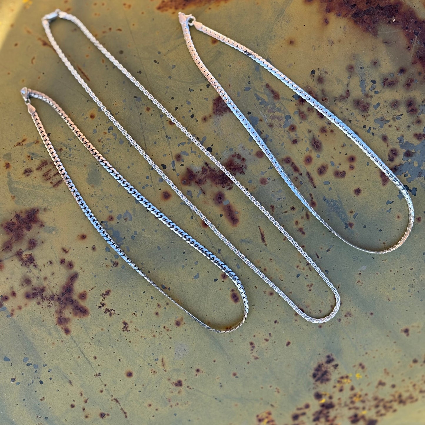 Silver chain on a rusty metal surface