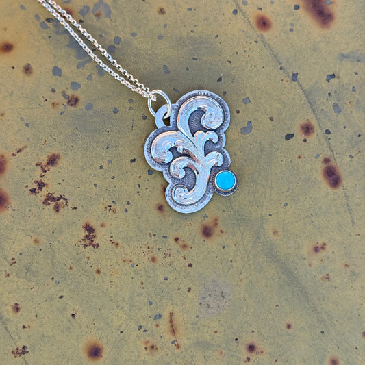 Silver necklace with a turquoise cabochon a textured surface